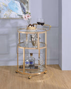 Three Tier Metal Serving Cart with Glass Inserted Shelves and Curved Side Handle, Gold and Clear